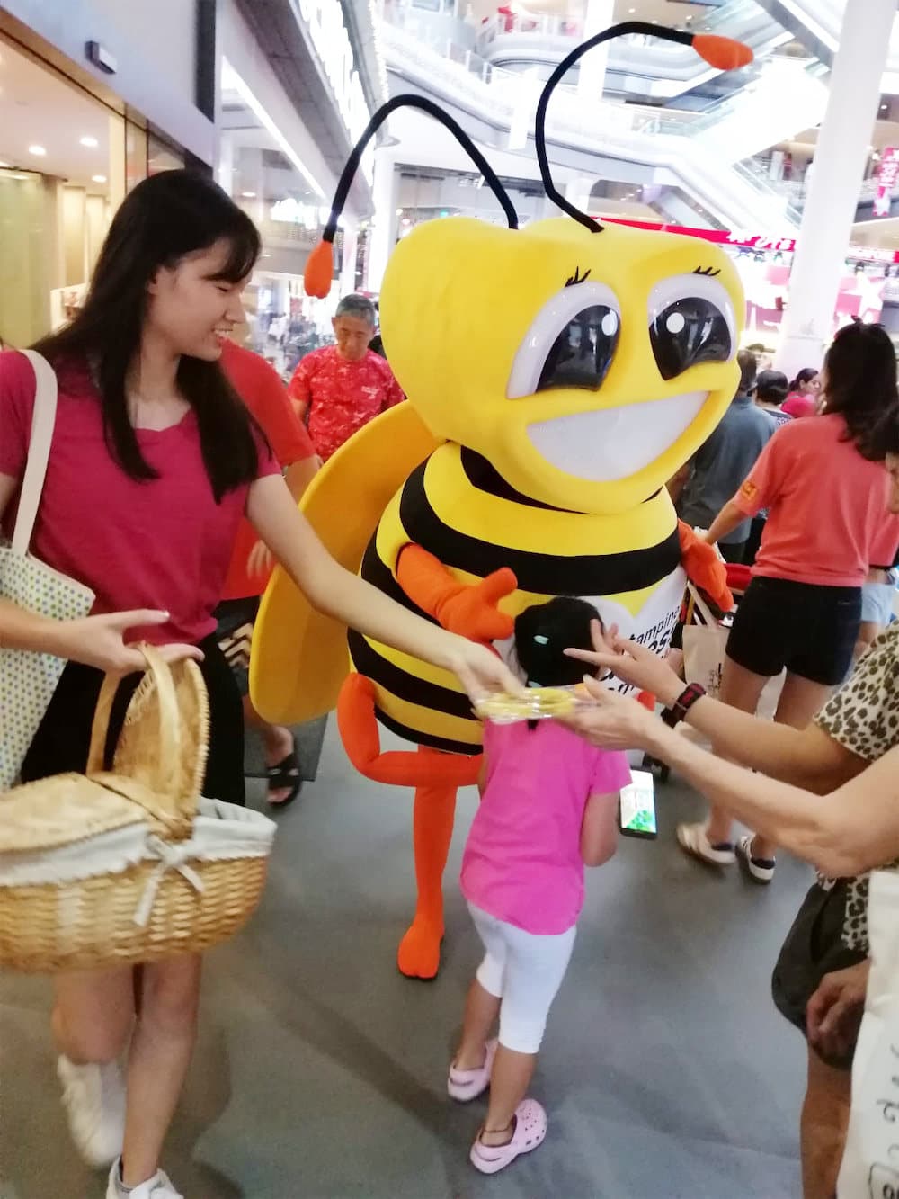 Walkway flyer distribution tampines hub bee mascot with distributor and crowd