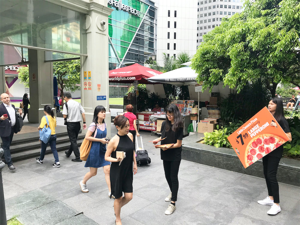 caesar walkway flyer distribution raffles place with distributors holding ad board and distributing flyers 2