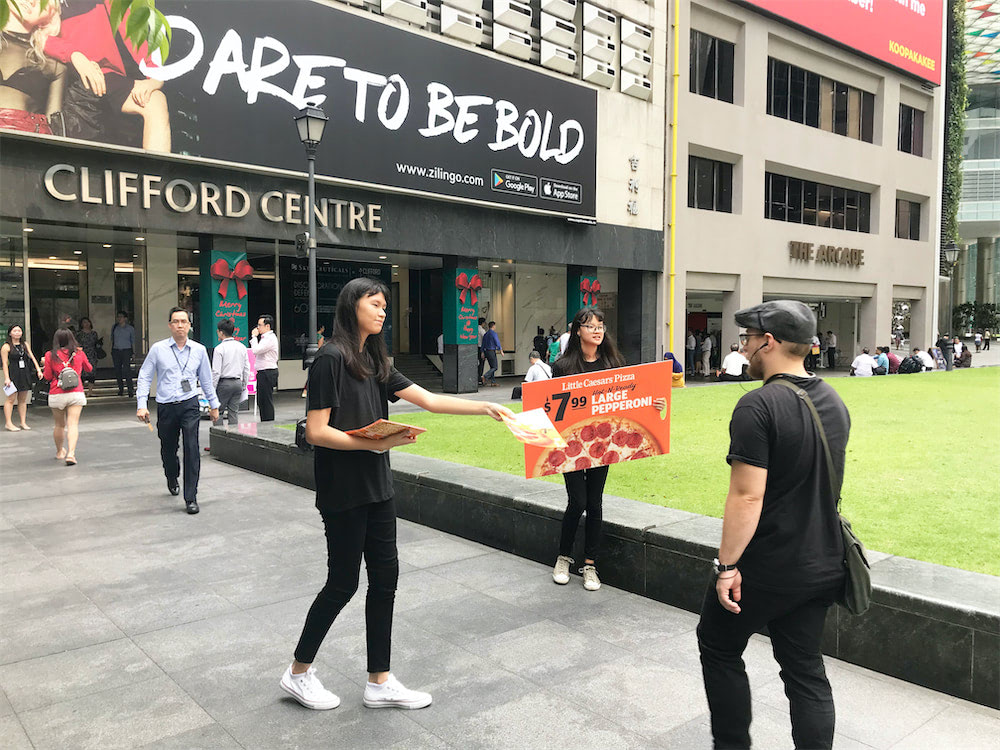 caesar walkway flyer distribution raffles place with distributors holding ad board and distributing flyers