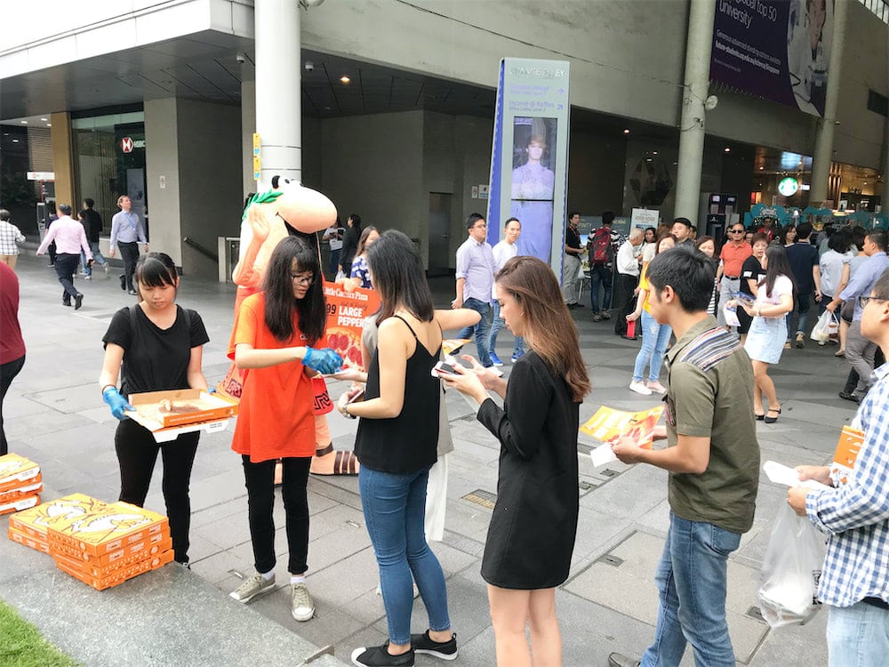 caesar walkway flyer distribution raffles place with mascot and people queuing for pizza