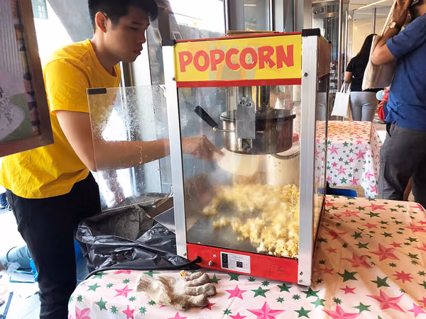 Indian Heritage Center Events flyer distribution marketing booth with popcorn machine and operator