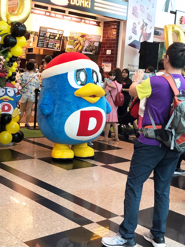 don don donki at changi jewel event marketing with mascot posing for photo with people 4