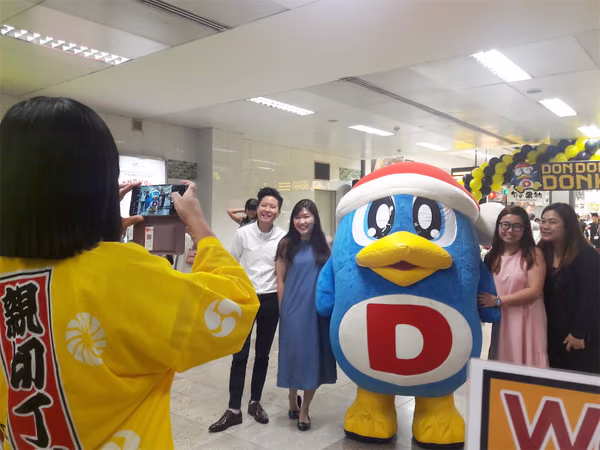 don don donki at novena event mascot with people posing for photo