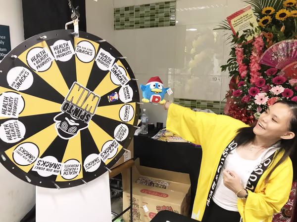 don don donki at novena event staff with spinning wheel scaled
